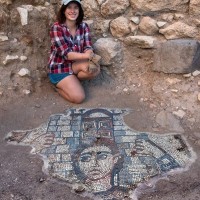 Megan kneeling in front of a mosaic